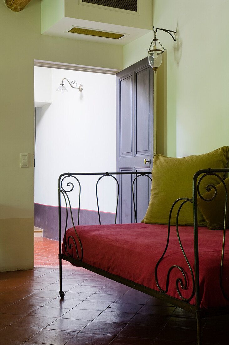 Day bed with red cover and green cushion