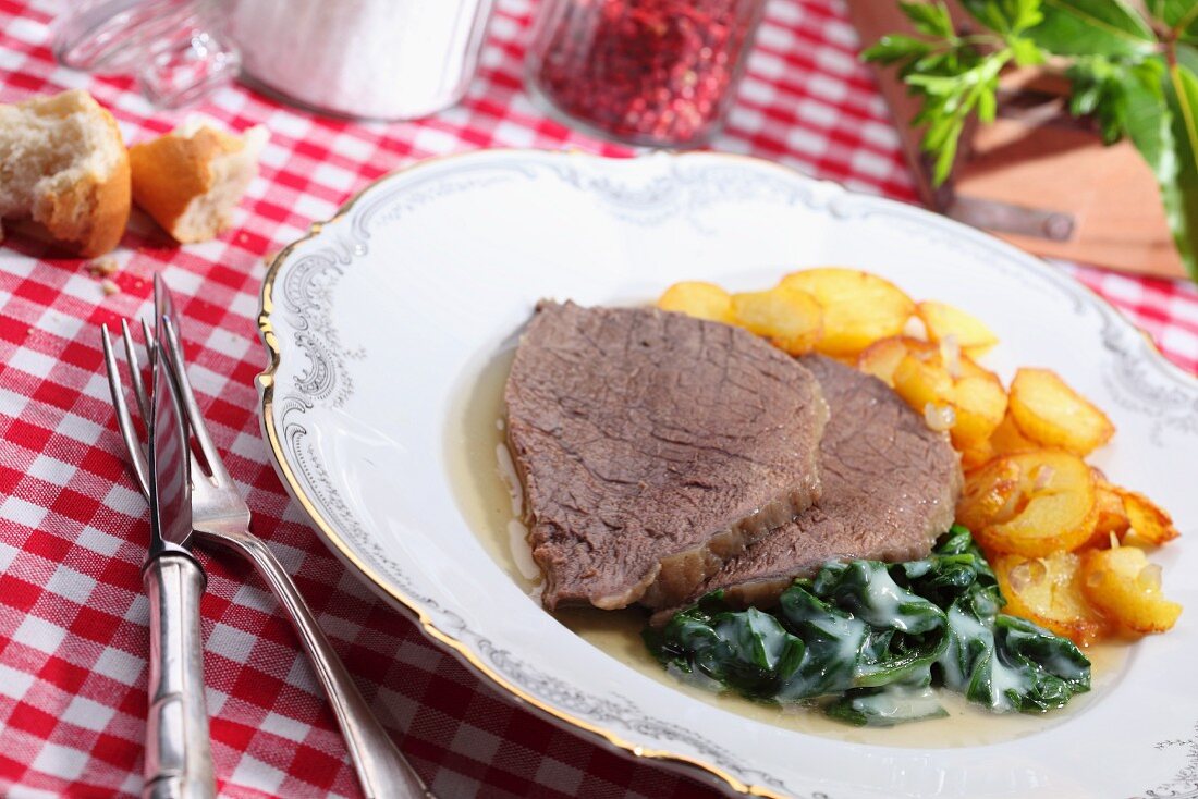 Boiled beef fillet with fried potatoes and spinach