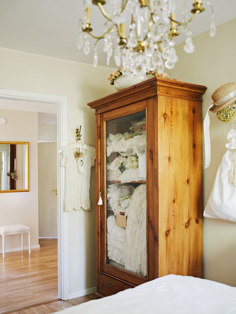 Glass-fronted wooden wardrobe in bedroom