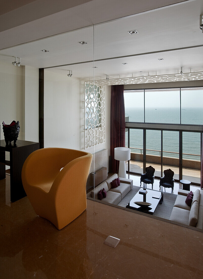 Living room with sea view, modern armchair and decorative ceiling element