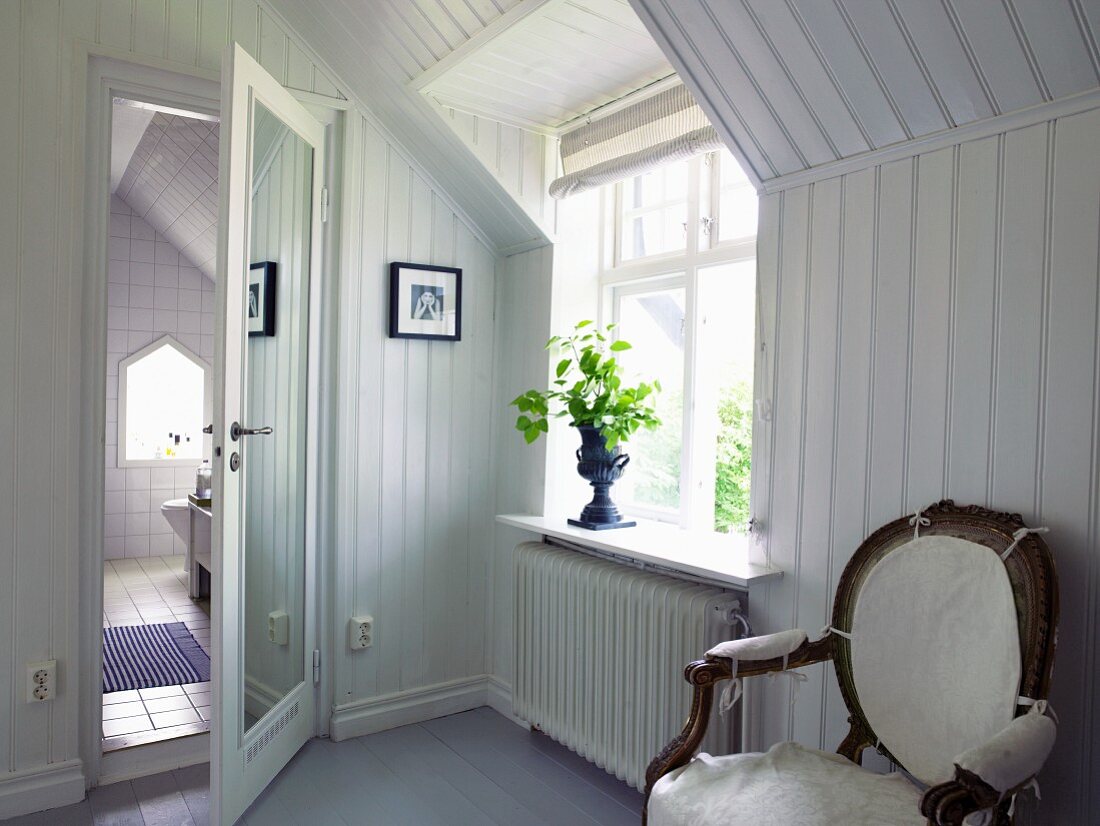 Wood-clad room with chair and view into bathroom