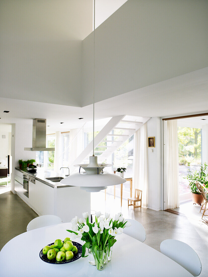 Modern kitchen with white interior and tulips on the table