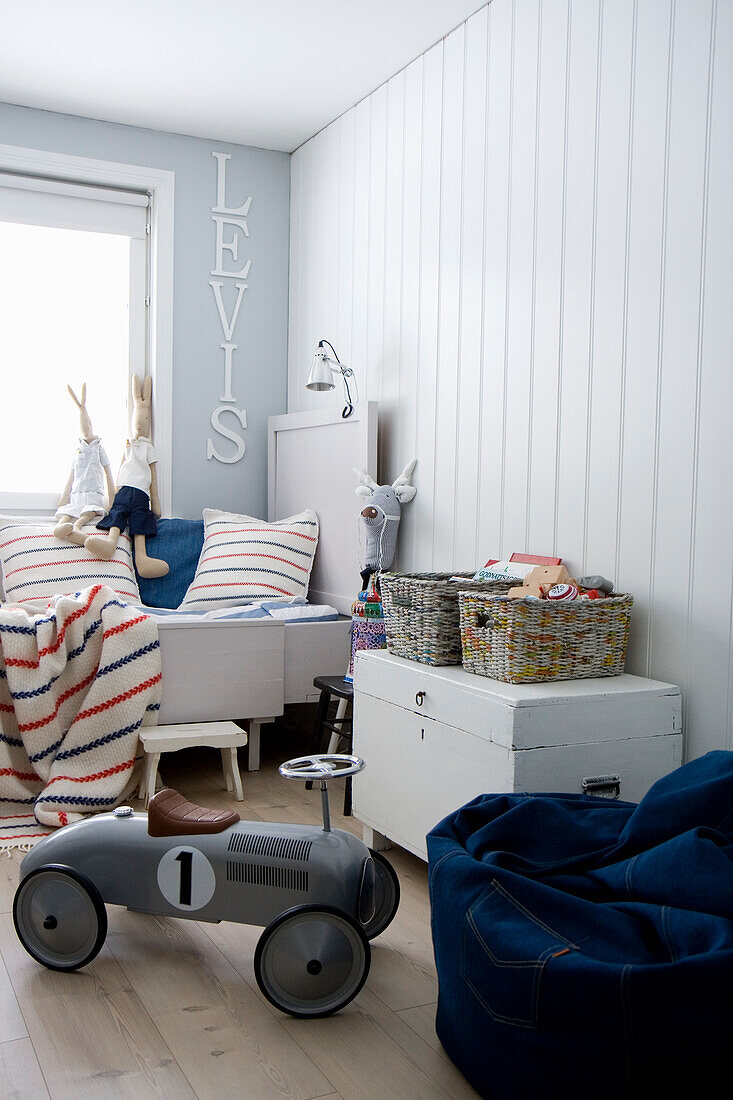 Children's room in white with toy car and blue beanbag chair