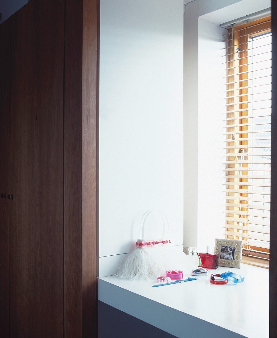 Handbag and jewellery on white windowsill