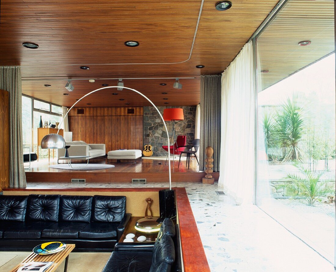 Fifties-style, open-plan living space with sofas in sunken seating area