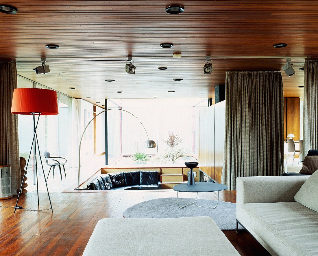 Spacious open-plan living space with light sofa and various Bauhaus-period standard lamps