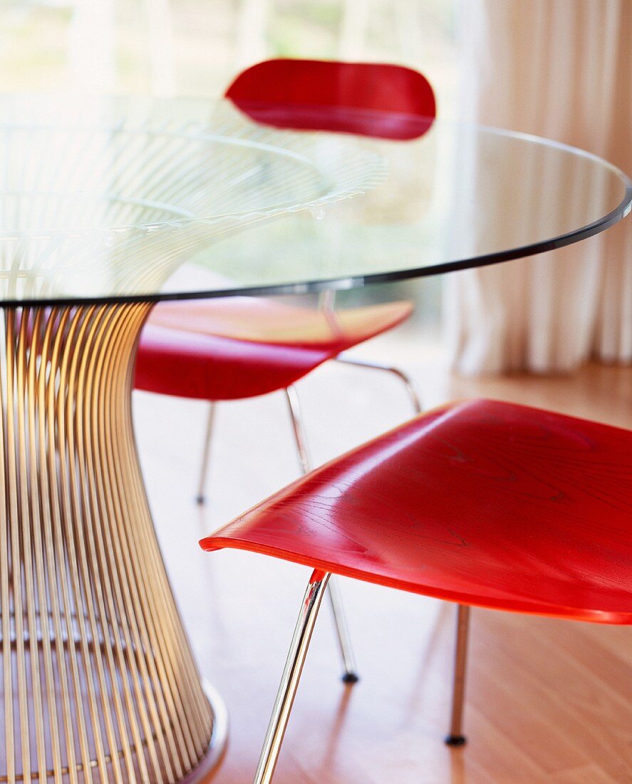 Rot gebeizte Holzstühle am Glastisch mit Metallfuss