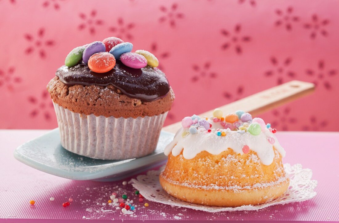 Chocolate muffin with colourful Smarties and mini bundt cake