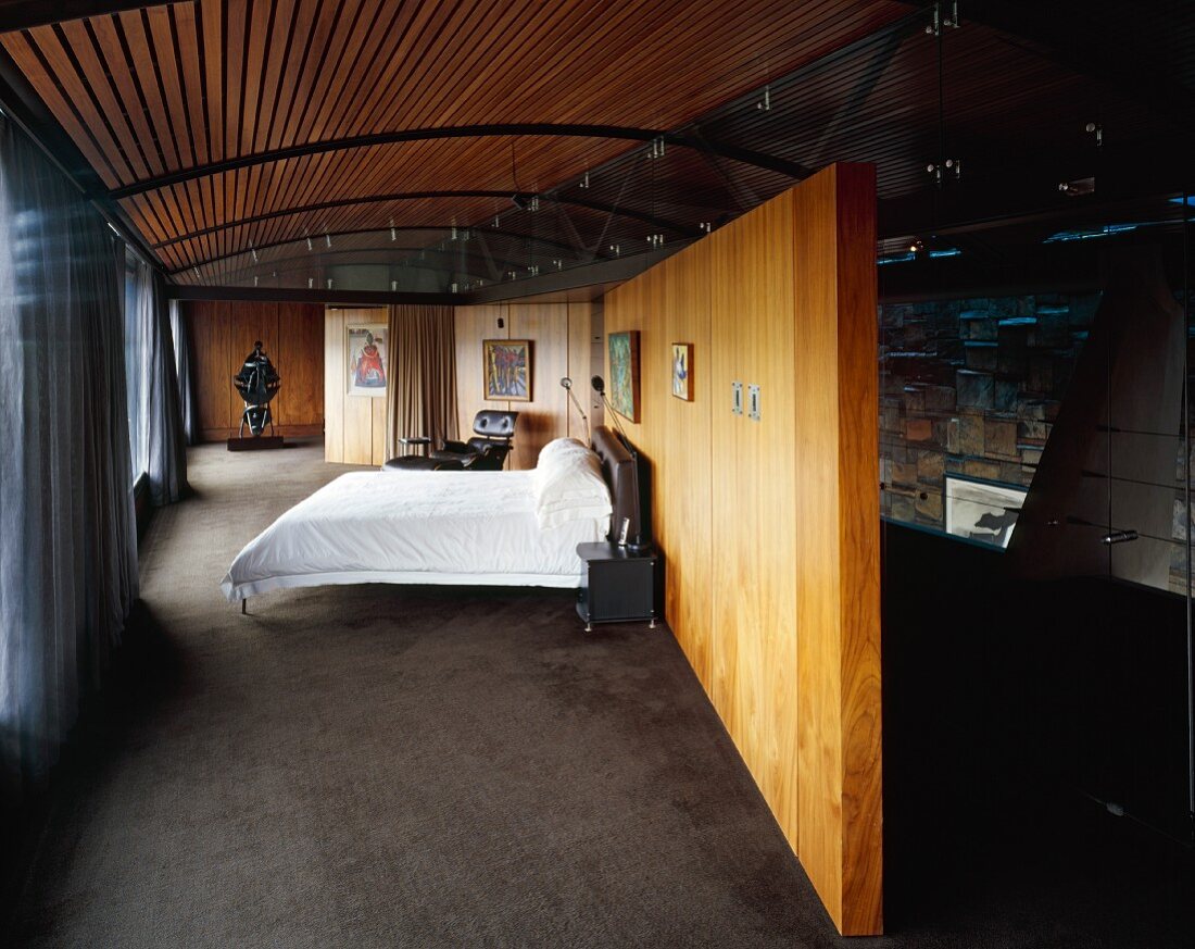 Bedroom with double bed in front of wooden partition