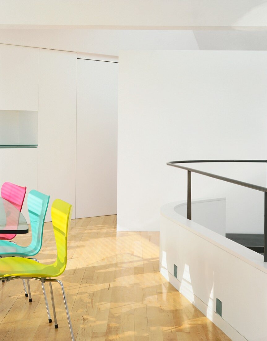 Detail of dining area with coloured chairs