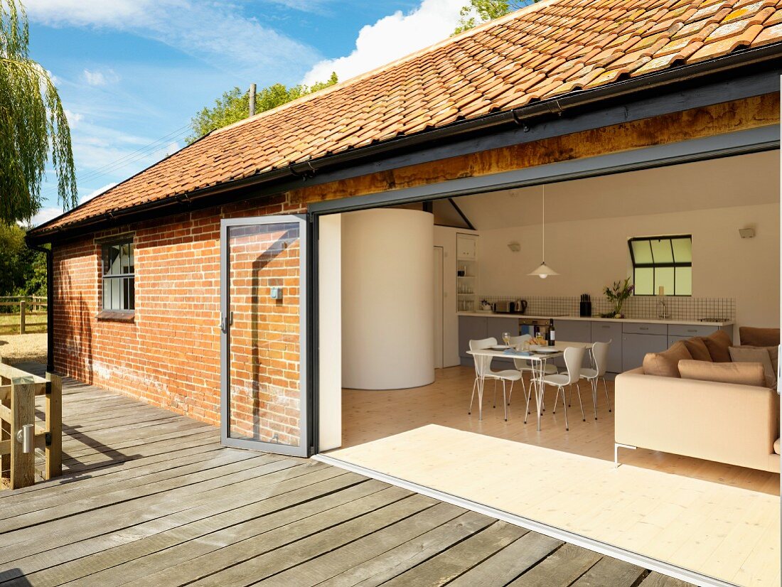 Blick von der Terrasse eines Landhauses in den Wohnraum