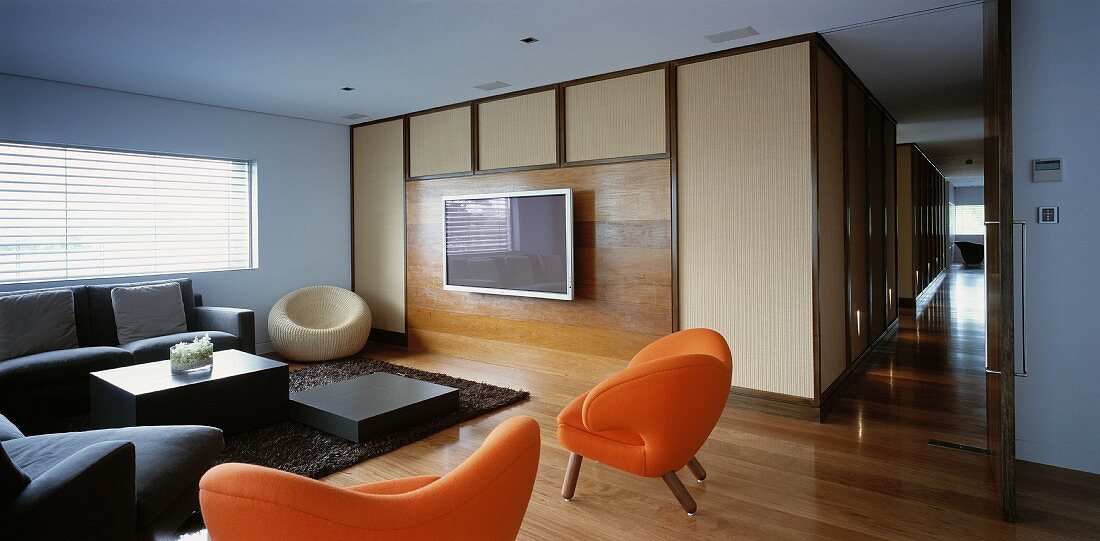 Living room with sofa, orange armchairs & TV