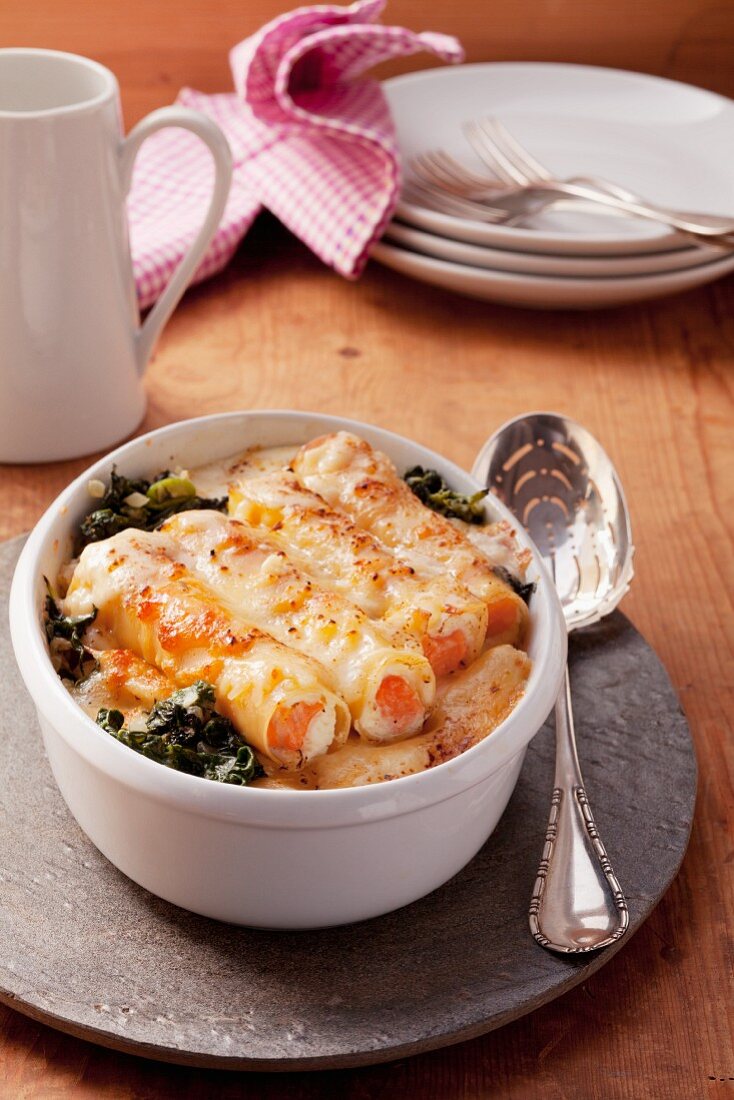 Cannelloni filled with salmon and ricotta on a bed of spinach