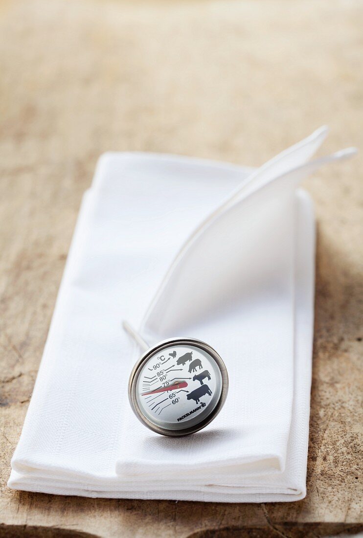 A meat thermometer on a white cloth