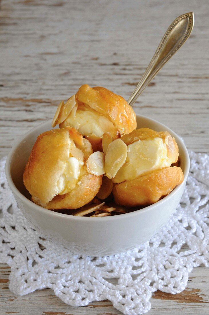 Vetkoek (South African deep-fried pastry) with cream cheese and slivered almonds