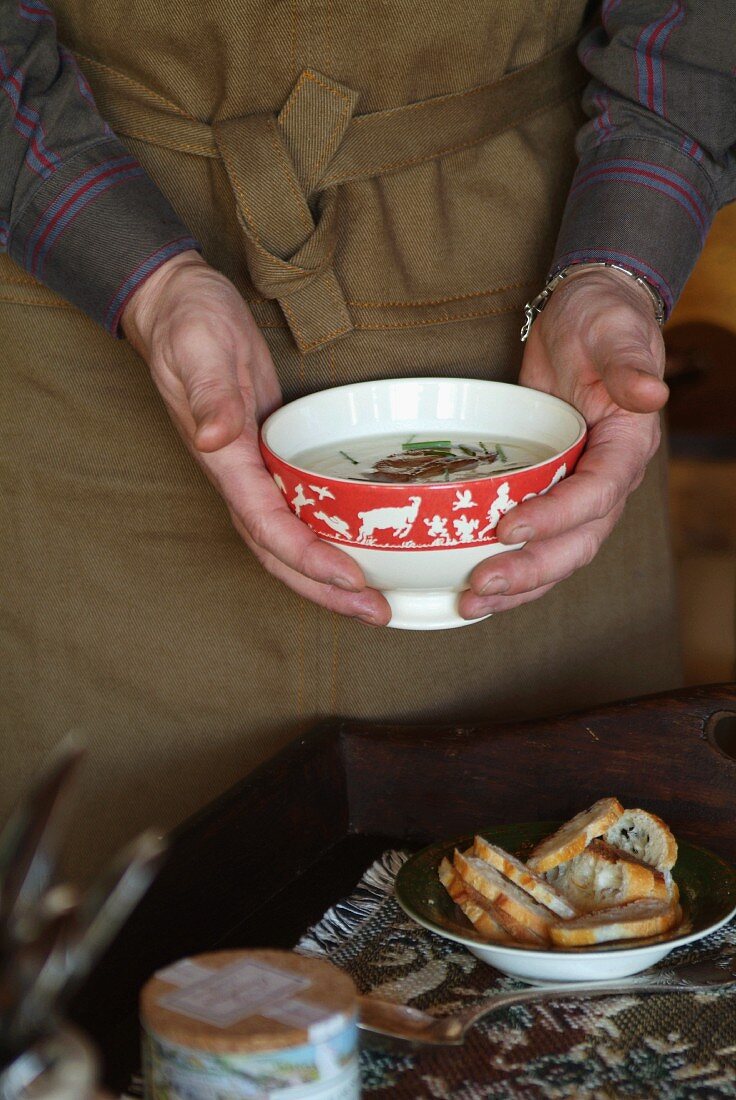 A woman serving cream of mushroom soup