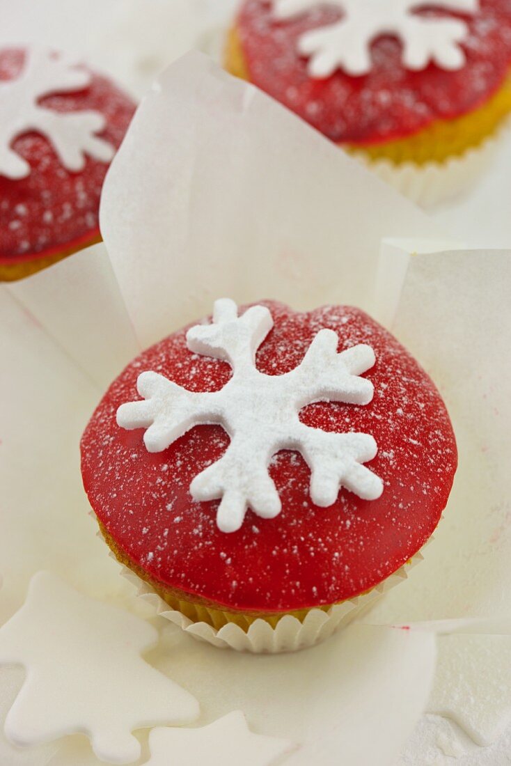 Cupcakes decorated with red icing and snowflakes