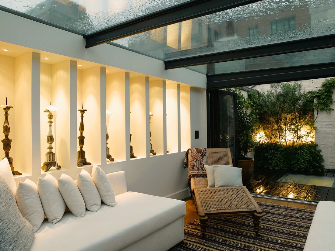 Living room with white sofas and antique couch in modern conservatory