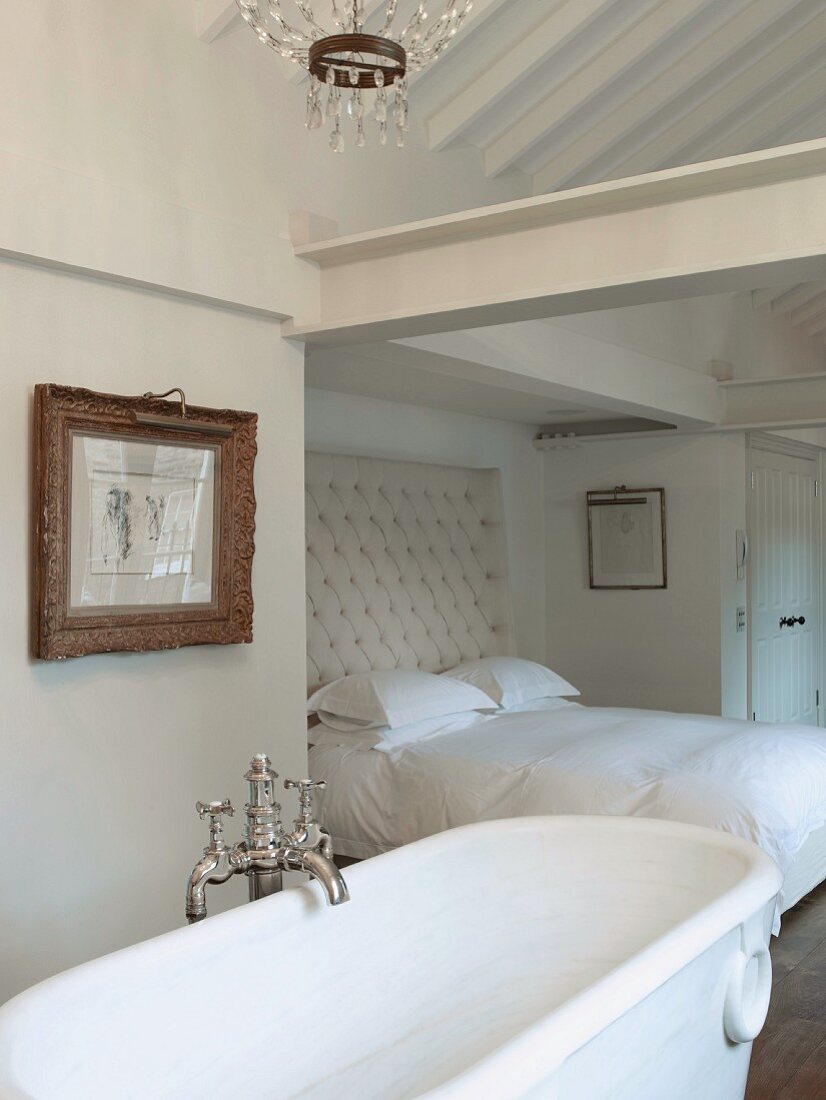 Free-standing white bathtub in bedroom with classic atmosphere