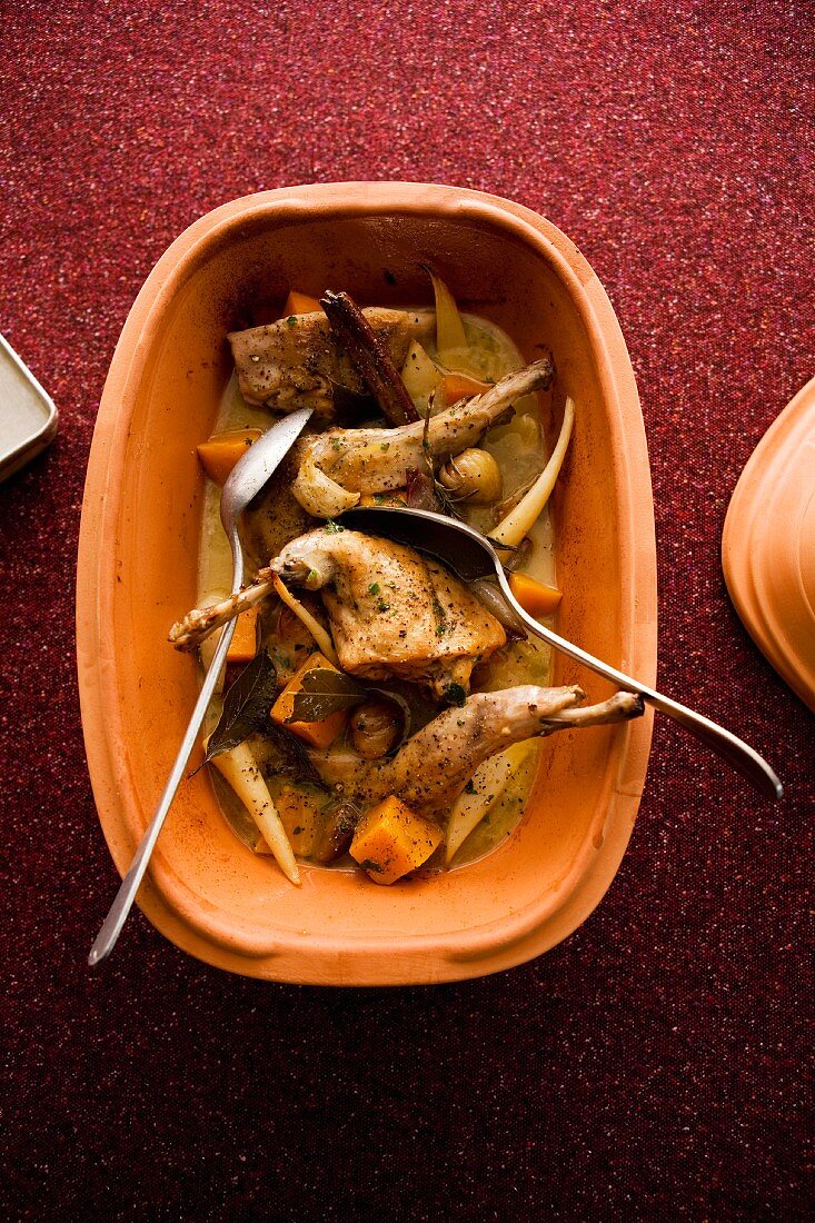 Rabbit with root vegetables in clay pot