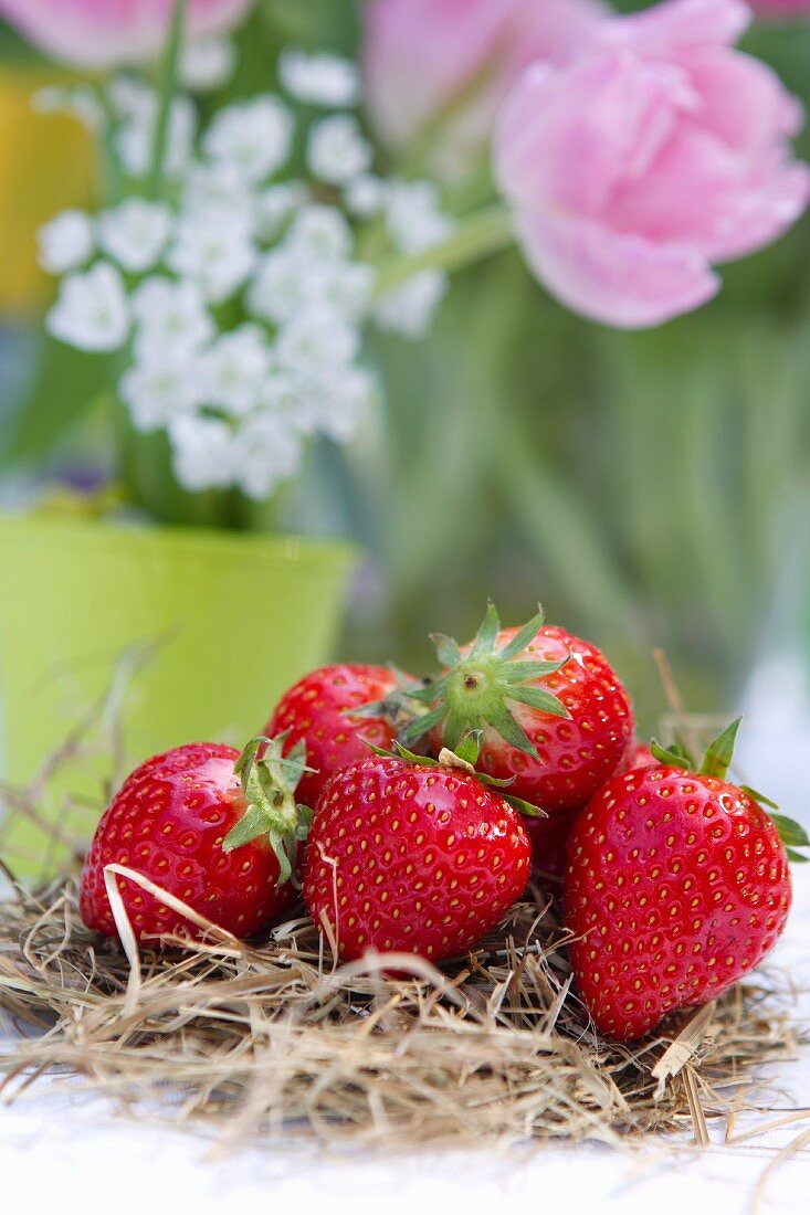 Tischdeko mit Erdbeeren auf Stroh