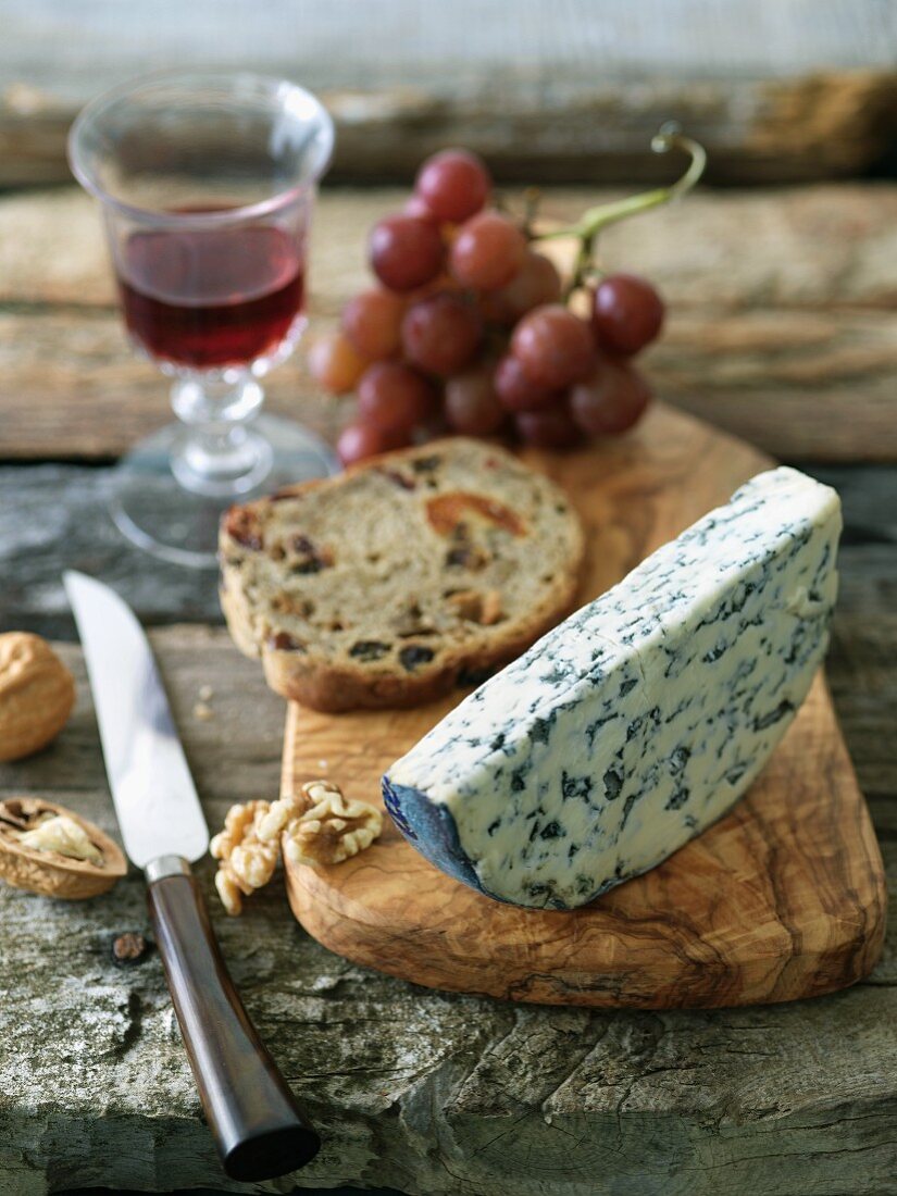 Fourme d'Ambert Cheese with Fruit Bread and Walnuts on a Board with a Knife