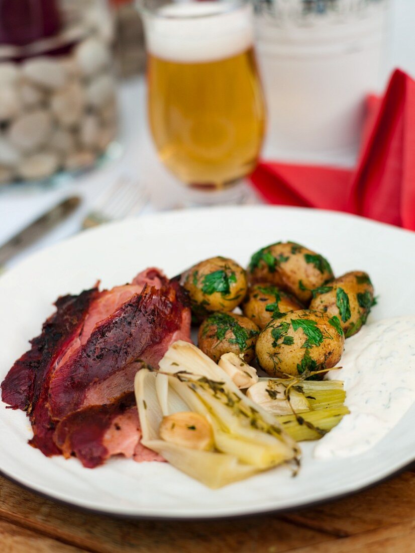 Barbecue leg of wild boar with herb potatoes and leeks