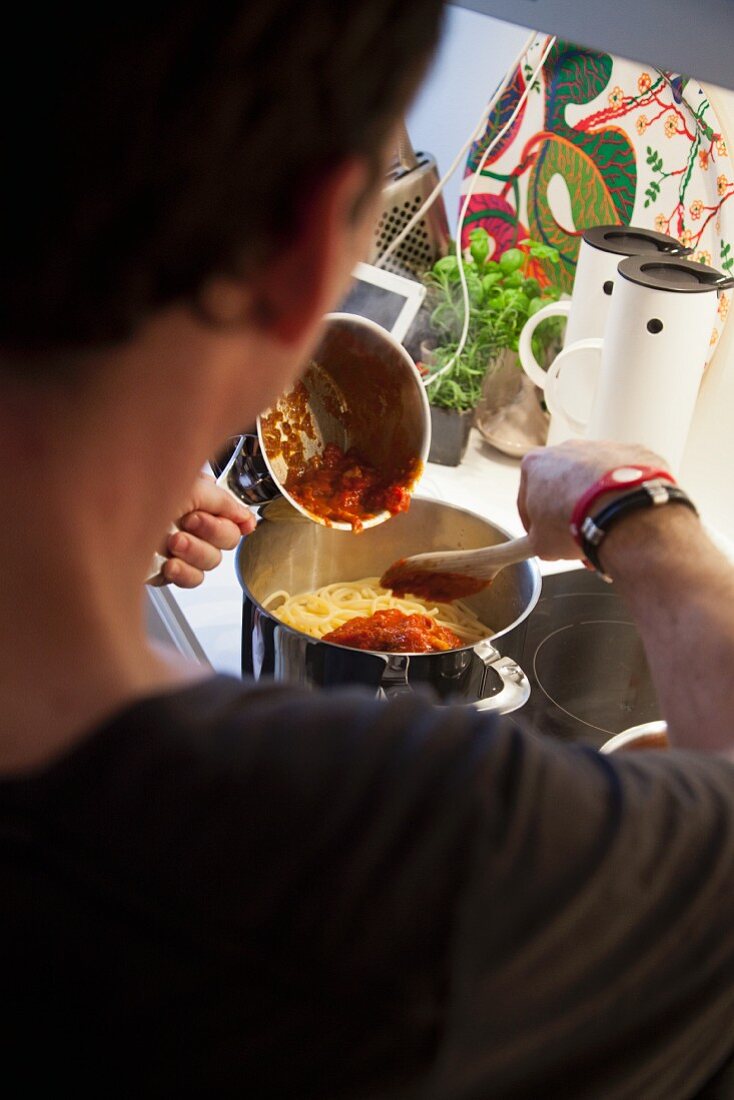 Spaghetti mit Tomatensauce vermengen