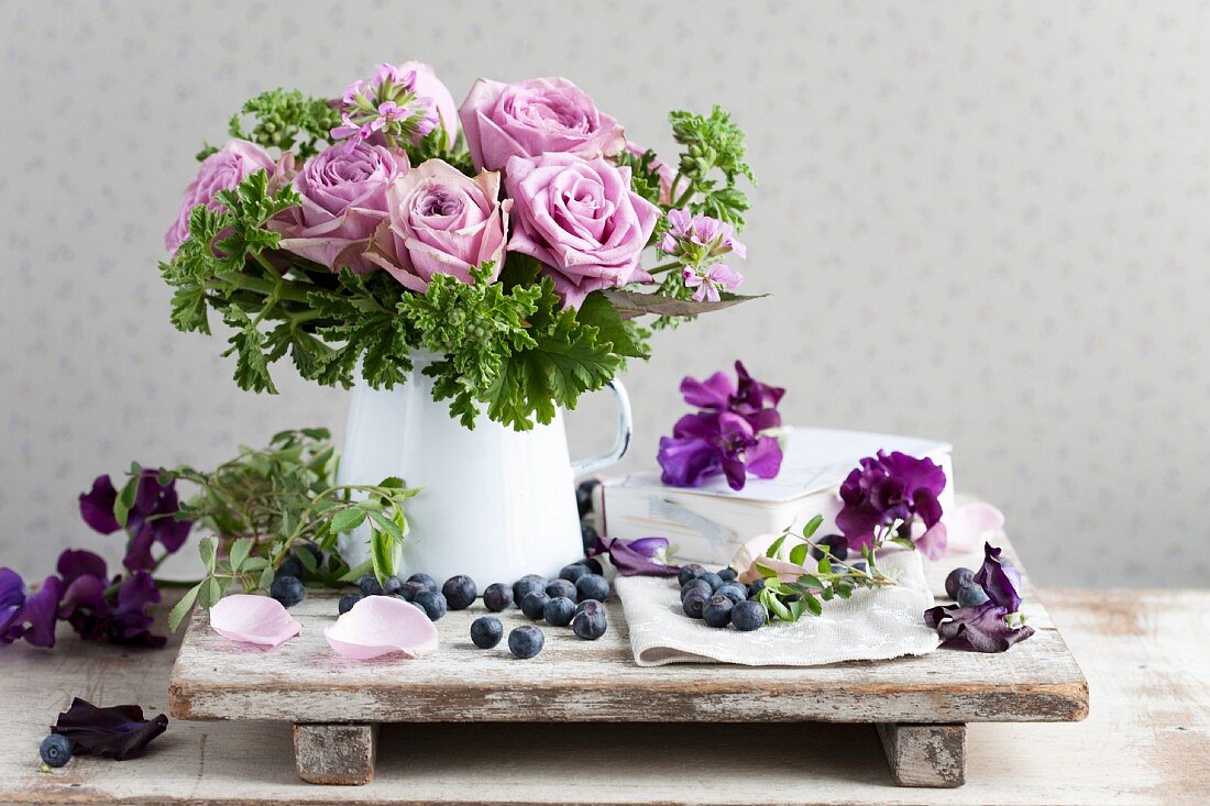 Bouquet of scented roses and scented pelargoniums surrounded by sweet peas and blueberries