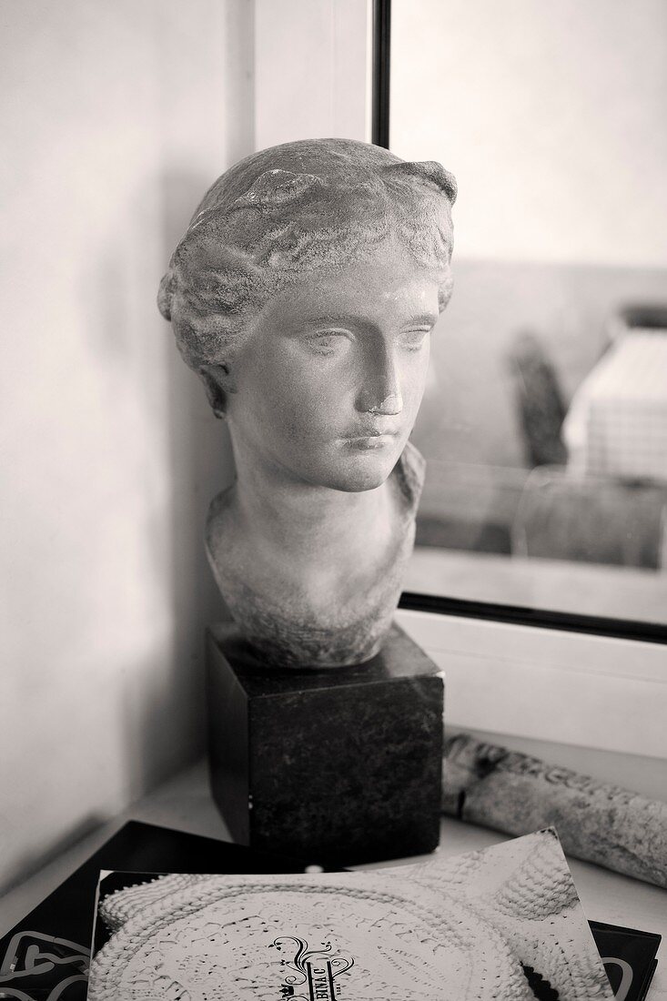 Antique bust in front of window