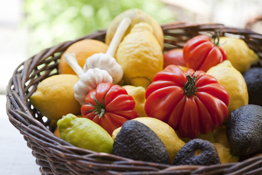 Basket of tomatoes, lemons, garlic and avocado