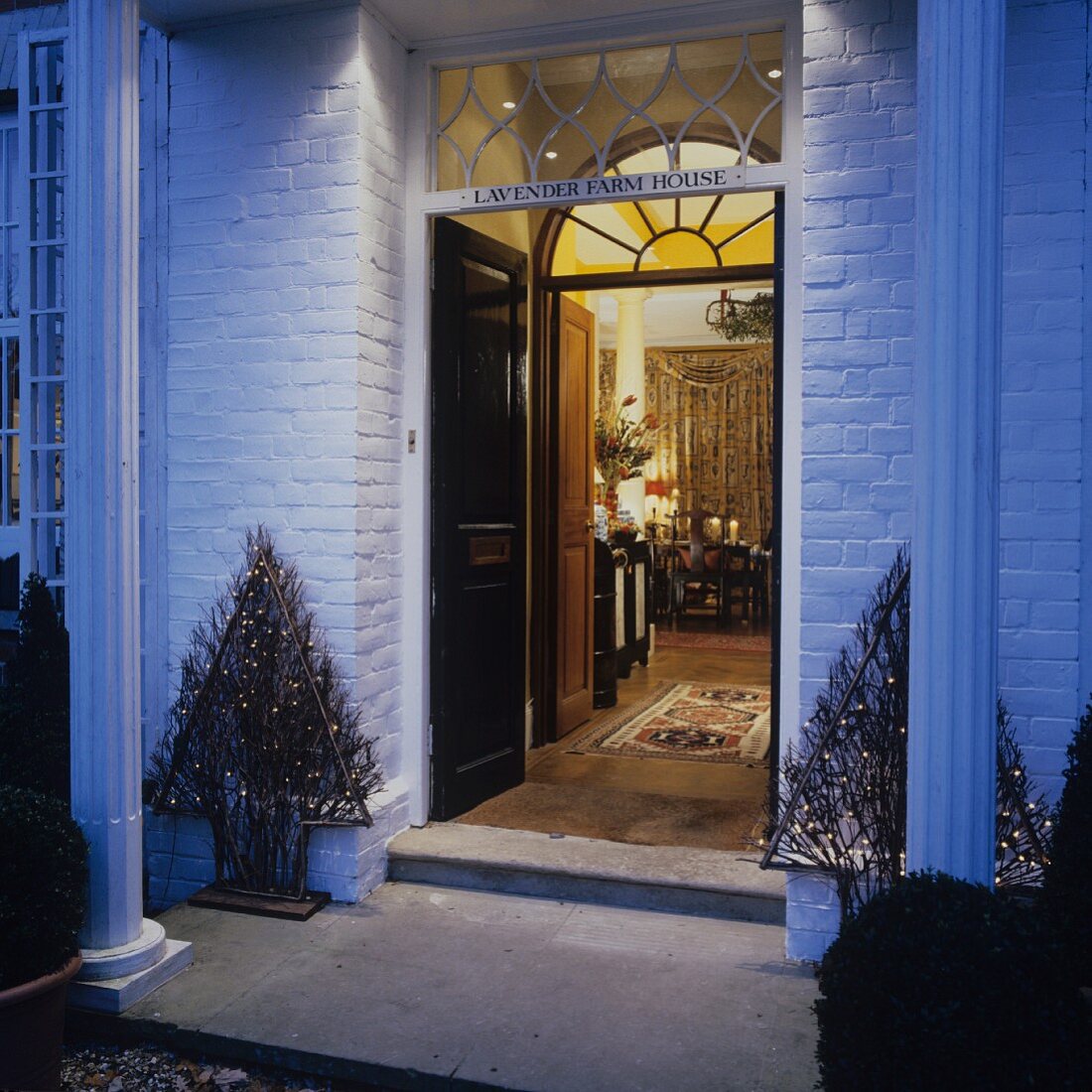 Entrance to English house with Christmas decorations and open door with view into interior room