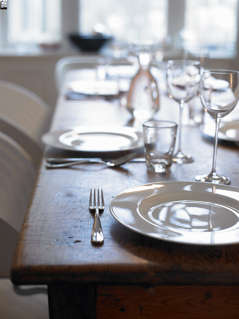 Set table with white crockery and glasses