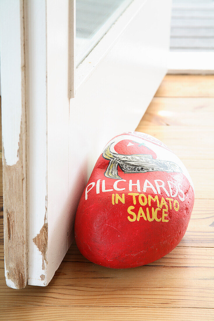 Bemalter Stein als Türstopper mit der Aufschrift "Pilchards in Tomato Sauce"