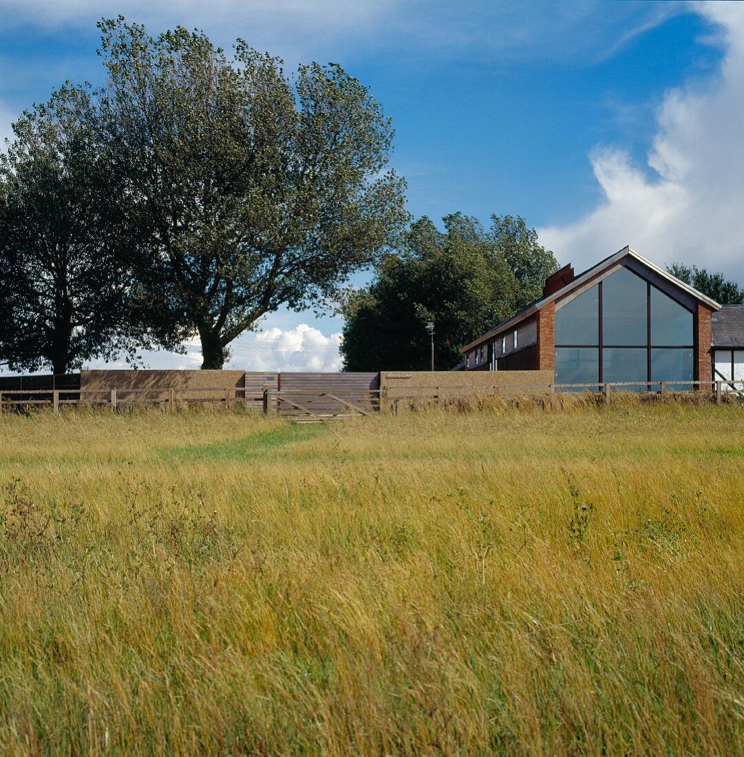 Blick von dem Feld auf das Wohnhaus mit Glasfront