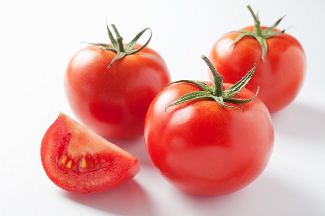 Tomatenspalte vor ganzen Tomaten