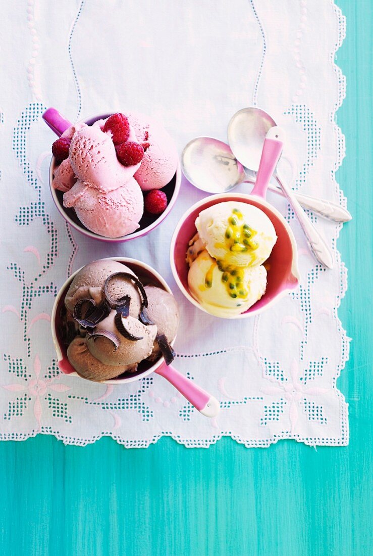 Home-made raspberry ice cream, passion fruit ice cream and chocolate ice cream in bowls