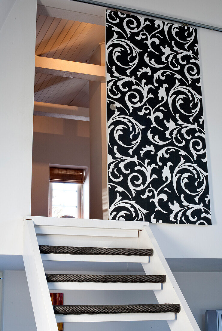 Staircase and black sliding door with white ornaments