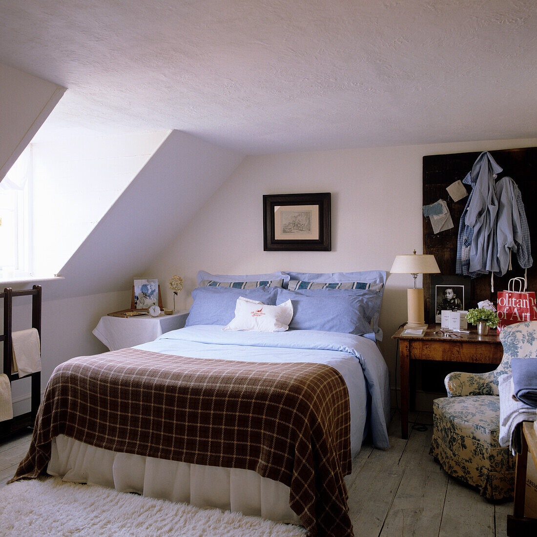 Dachschrägen-Schlafzimmer mit kariertem Bettbezug und Blaunuancen