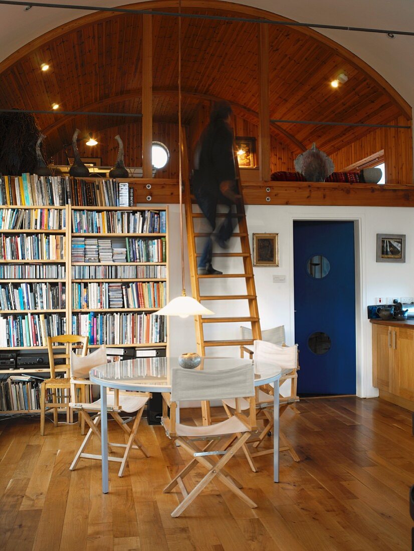 Two-storey living space with wood-panelled, arched ceiling on gallery level