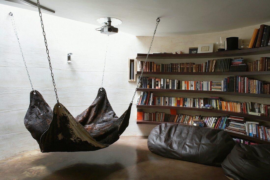 Indirect light from above in round reading corner with animal skin hammock and beanbags