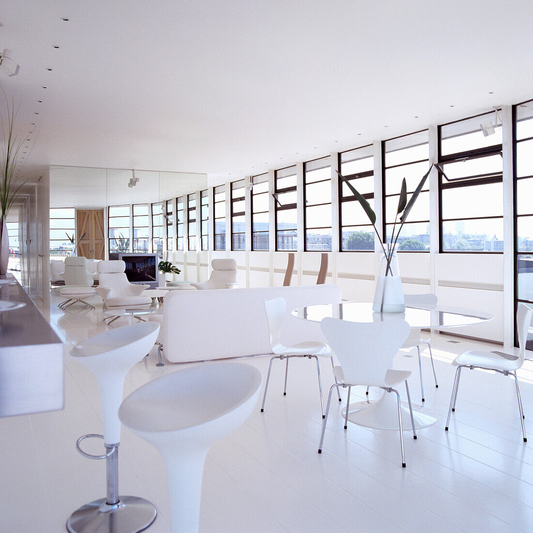 Bright living room with floor-to-ceiling windows and white furniture