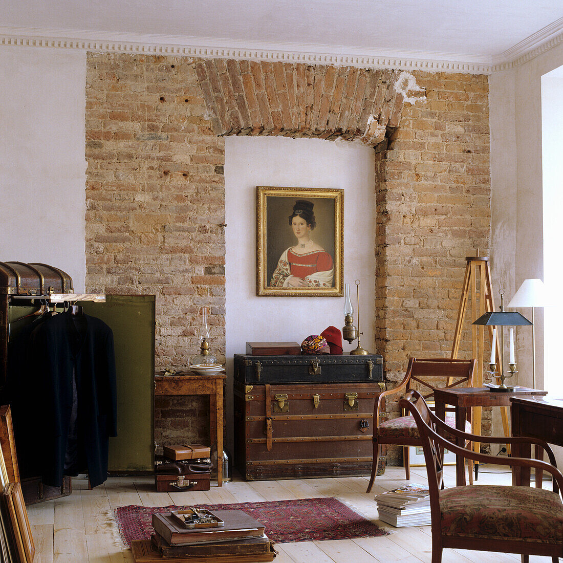 Room with brick wall, antique furniture and paintings