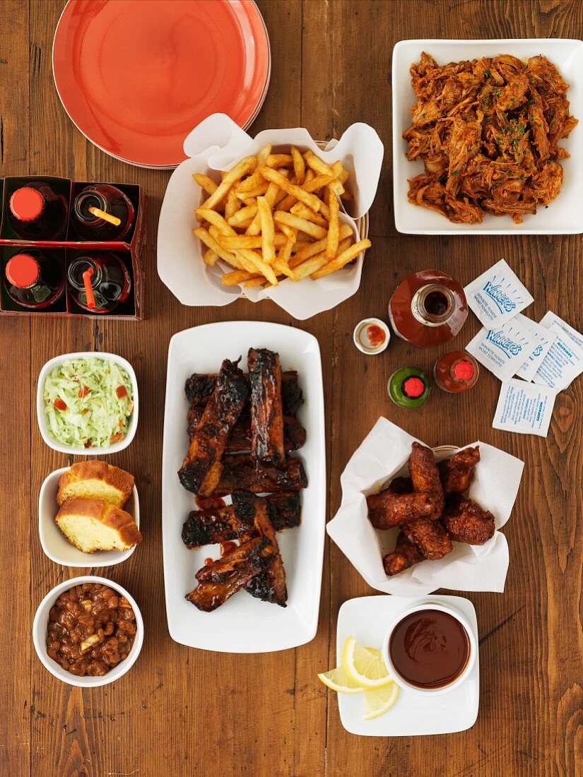Various fast food dishes (spare ribs, chicken wings, pulled pork, chips)