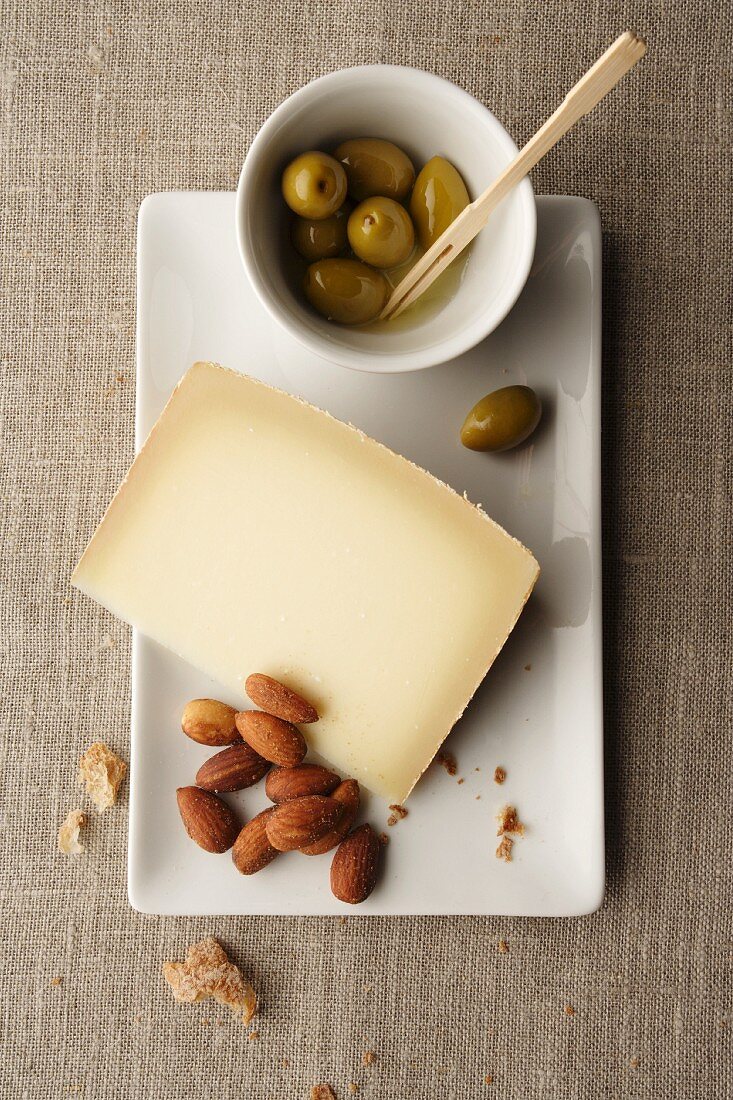 A slice of mountain cheese, almonds and olives
