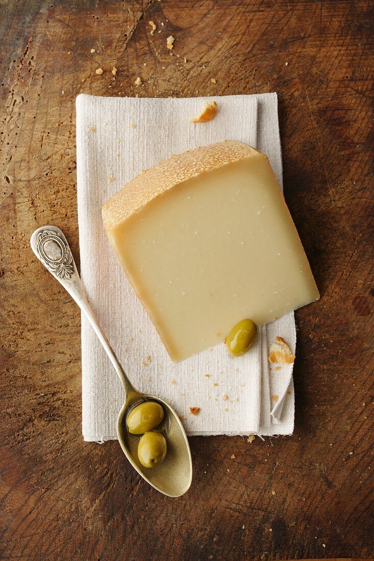 A slice of Gruyere cheese and olives