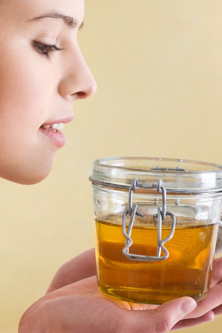 Junge Frau mit einem Glas Honig