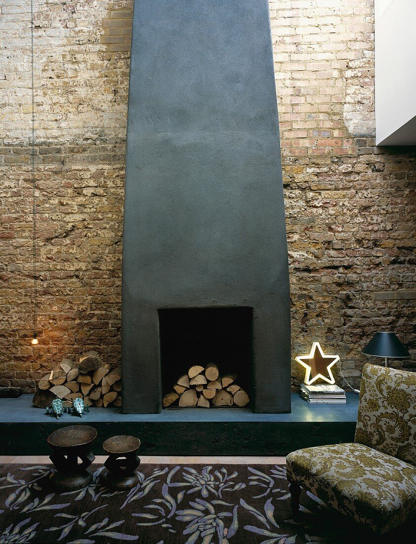 Armchair & rug in front of fireplace on brick wall