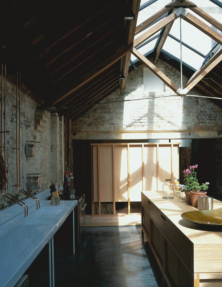 Open-plan kitchen in room with wood & glass roof structure