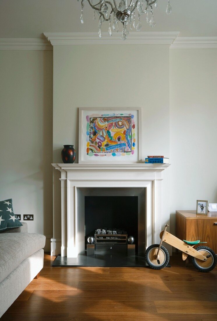Kaminzimmer mit modernem Gemälde und bequemer Couch